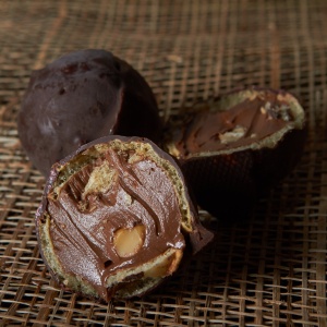 Шар из тёмного шоколада с орехом и вафлей.