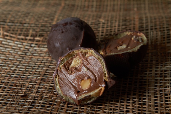 Фотография Шар из тёмного шоколада с орехом и вафлей.